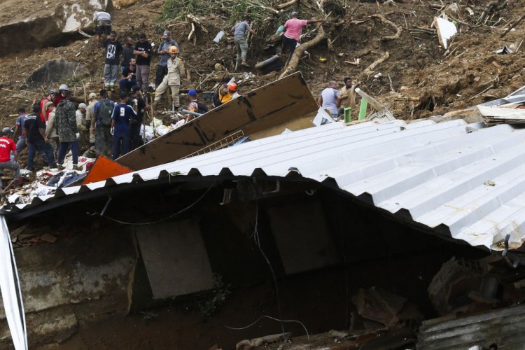 Bombeiros, moradores e voluntários trabalham no local do deslizamento no Morro da Oficina, após a chuva que castigou Petrópolis, na região serrana fluminense