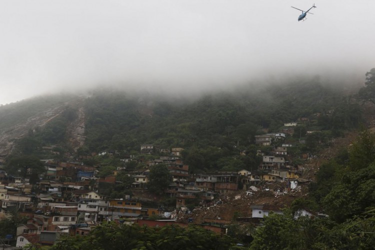 Bombeiros, moradores e voluntários trabalham no local do deslizamento no Morro da Oficina, após a chuva que castigou Petrópolis, na região serrana fluminense