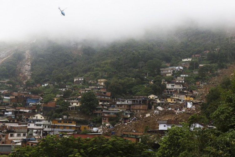 Bombeiros, moradores e voluntários trabalham no local do deslizamento no Morro da Oficina, após a chuva que castigou Petrópolis, na região serrana fluminense