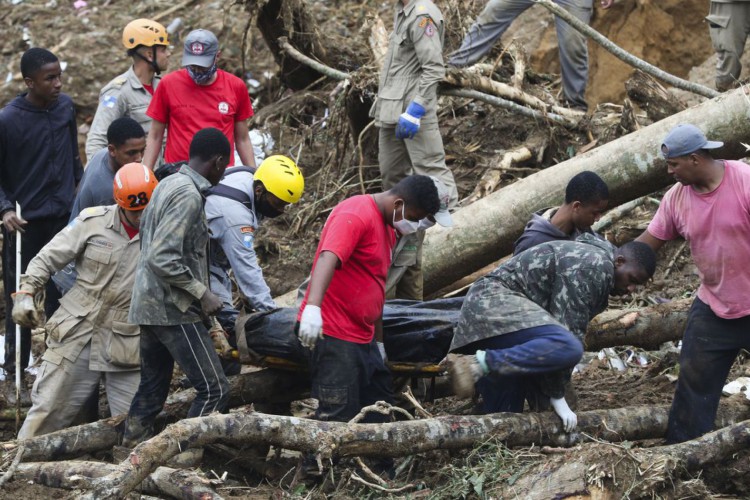 Bombeiros, moradores e voluntários trabalham no local do deslizamento no Morro da Oficina, após a chuva que castigou Petrópolis, na região serrana fluminense