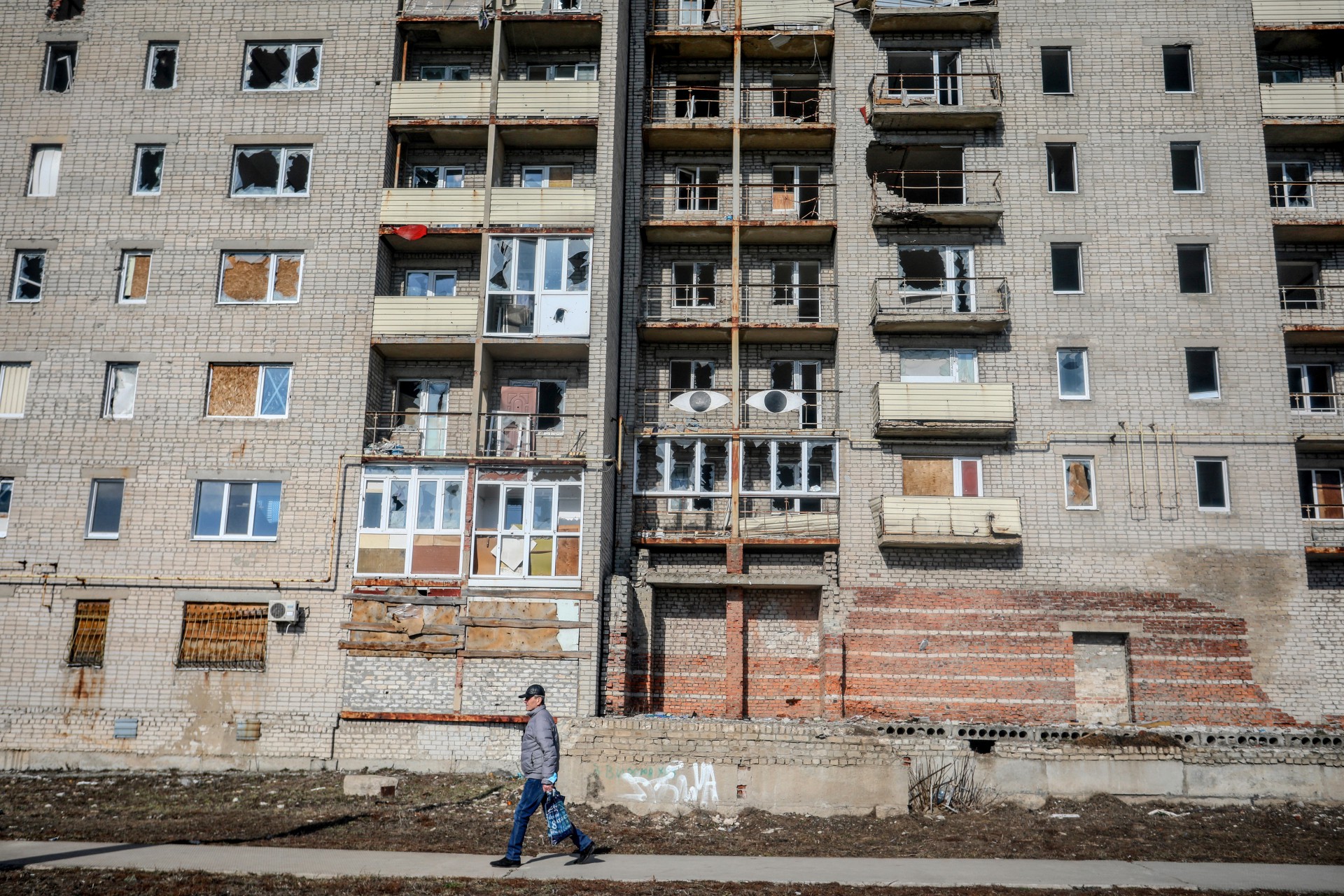 ￼ Homem caminha diante de prédio abandonado na cidade de Avdiivka, Donetsk, região separatista da Ucrânia (Foto: ALEKSEY FILIPPOV / AFP)