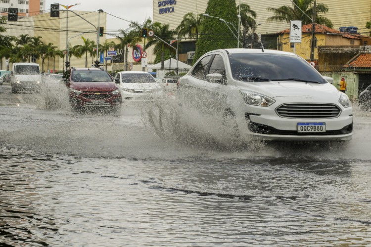 Risco de chuvas intensas se estende até este domingo, 13. Foto de apoio ilustrativo mostra carro atravessando poça de d'água na Av. Carapinima, em Fortaleza