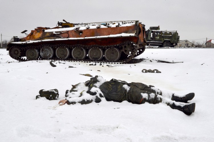 O corpo de um militar russo está perto de veículos militares russos destruídos na beira da estrada nos arredores de Kharkiv em 26 de fevereiro de 2022, após a invasão russa da Ucrânia