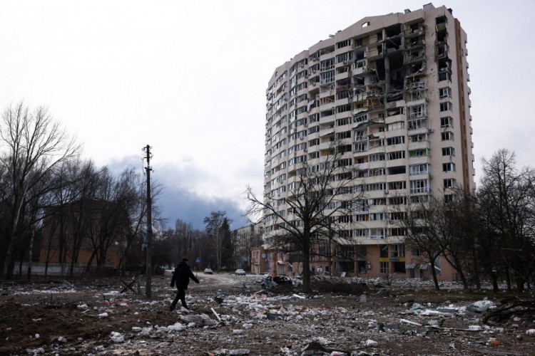 Um homem caminha em frente a um prédio residencial danificado no bombardeio de ontem na cidade de Chernihiv, na Ucrânia