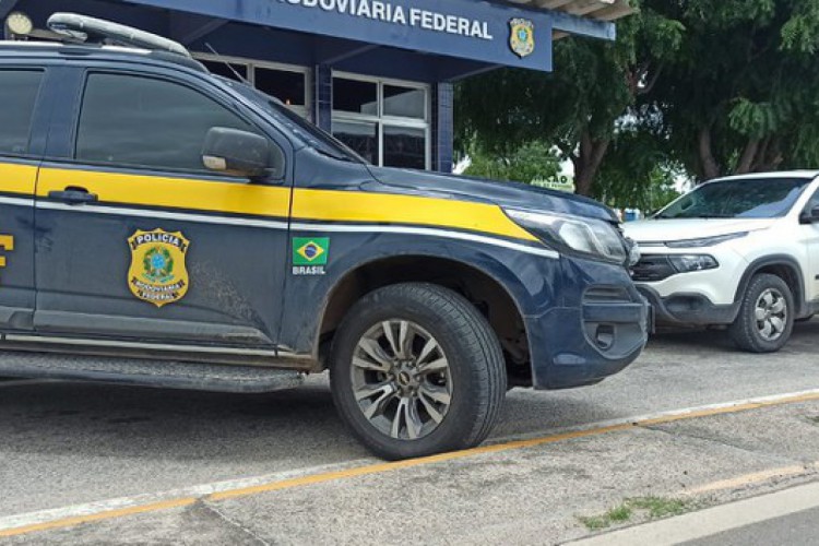 Veículo foi interceptado durante fiscalização de rotina da PRF nas rodovias federais do Ceará. A foto mostra o veículo apreendido ao fundo e a viatura da PRF em primeiro plano