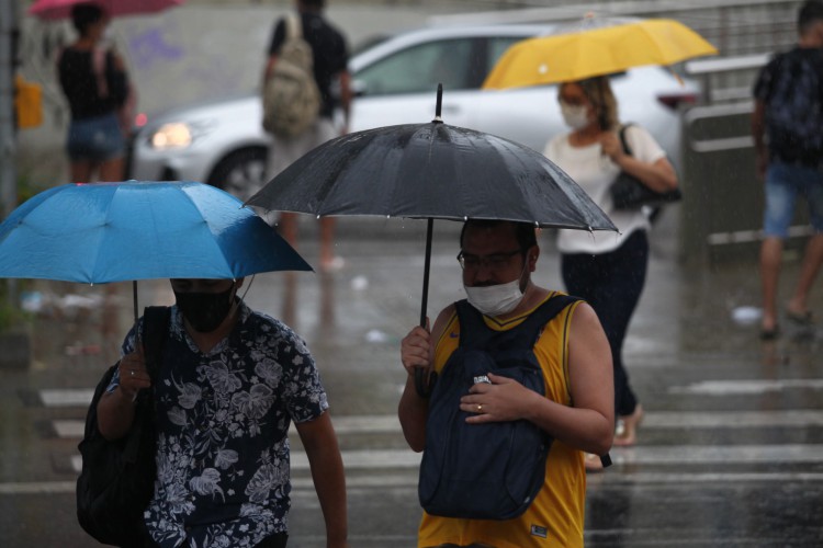 Pessoas se protegem da chuva em Fortaleza