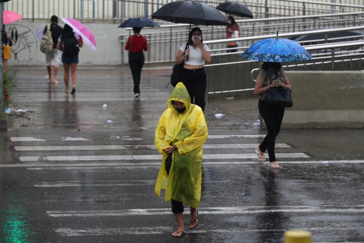 Pessoas se protegem da chuva. Manhã de chuva em Fortaleza. Av. Aguanambi, 11 de março