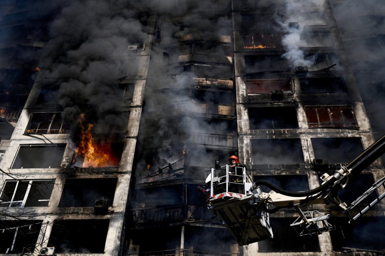 Bombeiros estão em um guindaste para apagar um incêndio em um prédio de apartamentos em Kiev, depois que ataques em áreas residenciais mataram pelo menos duas pessoas, disseram os serviços de emergência da Ucrânia enquanto as tropas russas intensificavam seus ataques à capital ucraniana. - Uma série de explosões poderosas abalaram bairros residenciais de Kiev na madrugada de hoje, matando duas pessoas, poucas horas antes de as negociações entre a Ucrânia e a Rússia serem retomadas