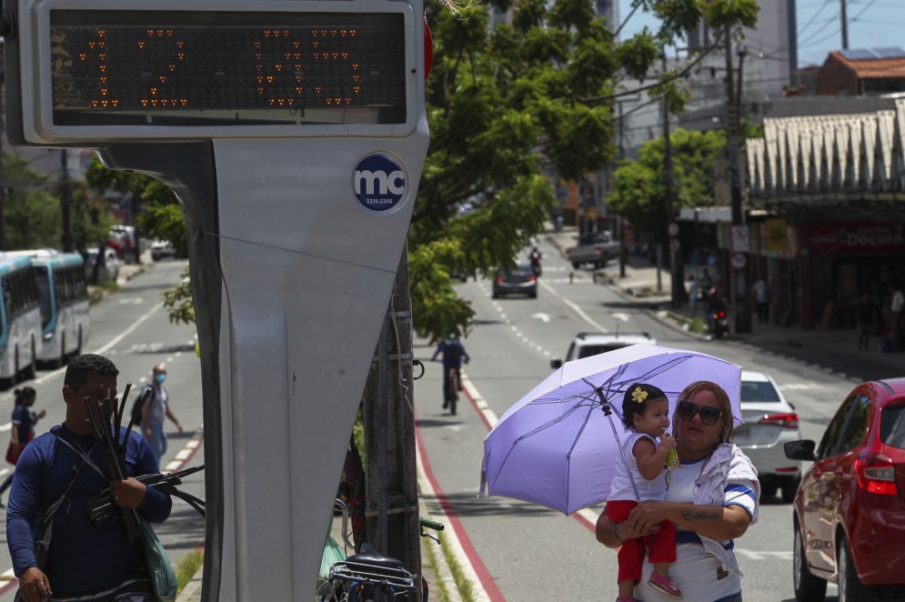 FORTALEZA,CE, BRASIL, 14.04.2022: Mulher protege criança do forte calor com sombrinha. Onda de calor em Fortaleza.    (Fotos: Fabio Lima/O POVO).(Foto: FABIO LIMA)