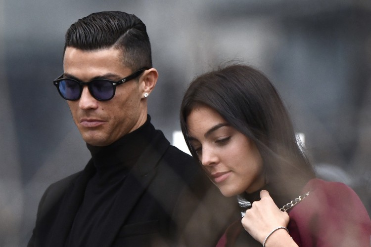 Nesta foto de arquivo tirada em 22 de janeiro de 2019, o atacante da Juventus e ex-jogador do Real Madrid, Cristiano Ronaldo, sai com sua namorada espanhola Georgina Rodriguez depois de comparecer a uma audiência judicial por evasão fiscal em Madri