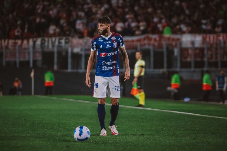 Lateral-esquerdo Juninho Capixaba com a bola no jogo River Plate x Fortaleza, no Monumental de Núñez, pela Copa Libertadores