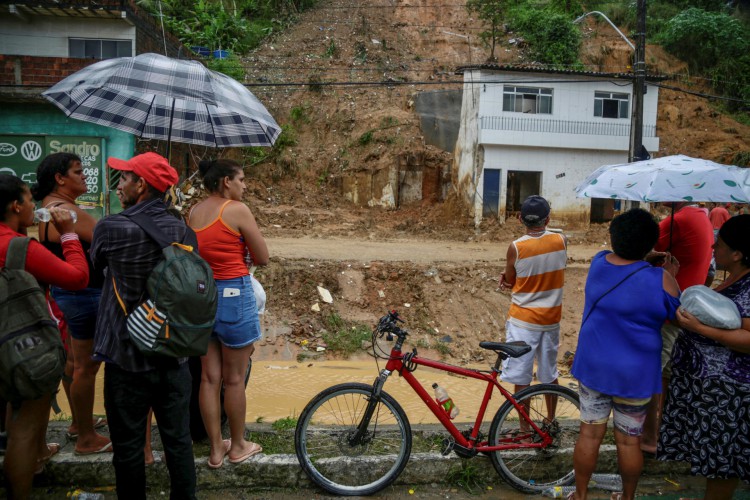 Moradores observam área de deslizamento de terra na comunidade Jardim Monte Verde, no bairro do Ibura, em Recife, Pernambuco. 