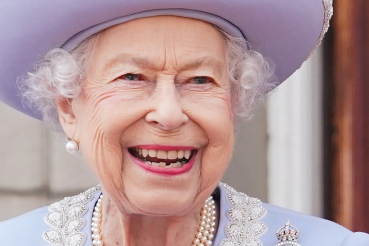 A rainha Elizabeth II da Grã-Bretanha fica na varanda do Palácio de Buckingham enquanto as tropas marcham durante o desfile de aniversário da rainha