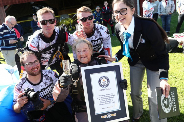 Rut Larsson, de 103 anos, recebe seu certificado de recorde do Guinness World Records, e comemora com paraquedistas depois que ela completou seu salto em Motala, Suécia, em maio 29, 2022