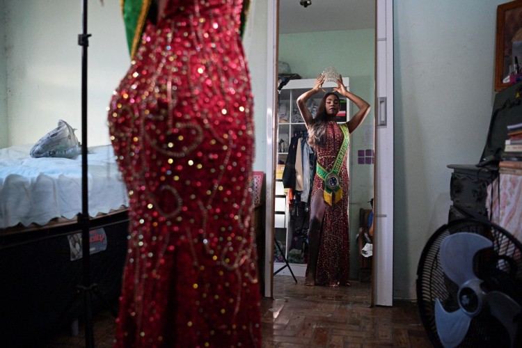 A modelo transgênero Eloa Rodrigues, 29, se olha no espelho enquanto se prepara para posar para fotos para a AFP em sua casa no Rio de Janeiro, Brasil, em 5 de maio de 2022. Eloa representará o Brasil no concurso Miss International Queen, a trans 