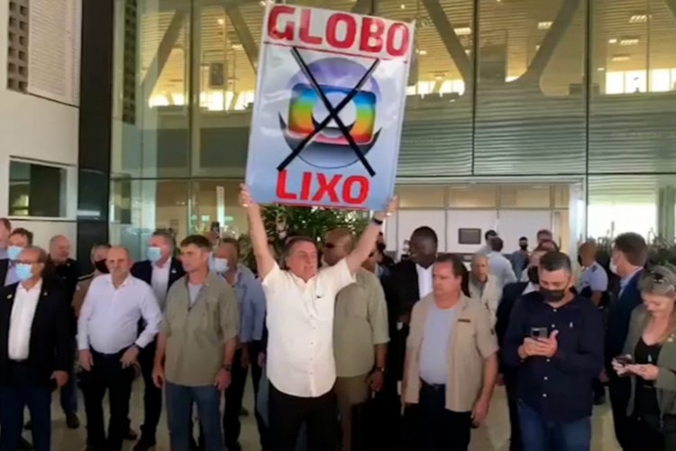 Presidente Jair Bolsonaro ergue um cartaz com a frase 