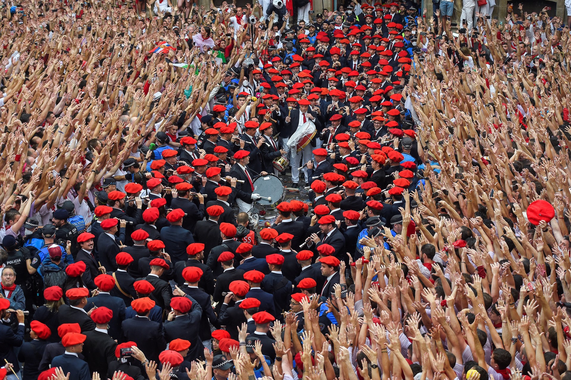 Os participantes comemoram enquanto a banda municipal de música "Pamplonesa" se apresenta durante a cerimônia de abertura "Chupinazo" (foguete de partida) para marcar o início do Festival de San Fermin fora da Prefeitura de Pamplona, ​​no norte da Espanha, em 6 de julho de 2022