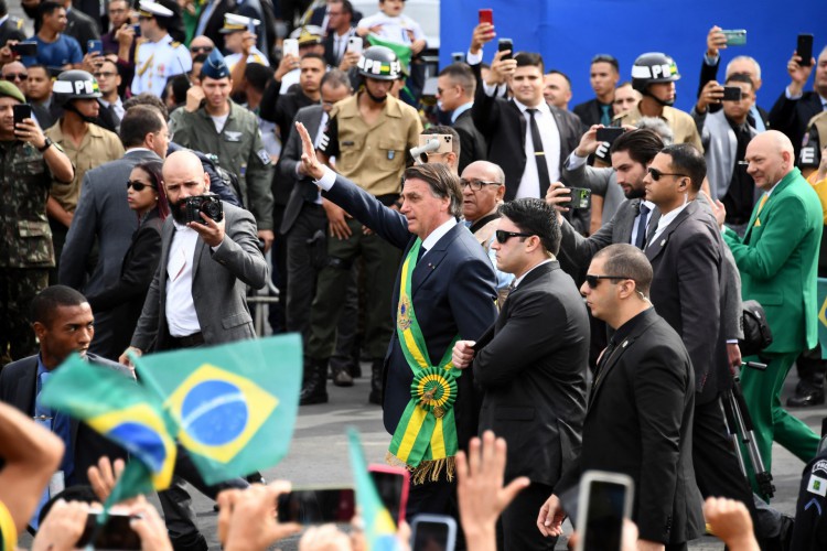 Presidente Jair Bolsonaro cumprimenta público no desfile de 7 de setembro, em Brasília. De verde, Luciano Hang, ao fundo