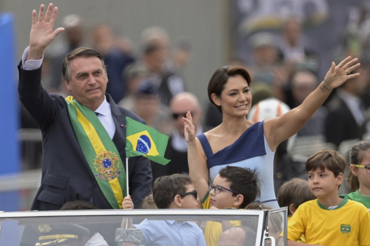 Brazilian President Jair Bolsonaro (L) and First Lady Michelle Bolsonaro wave during a military parade to mark Brazil's 200th anniversary of independence in Brasilia, on September 7, 2022. Desfile de 7 de setembro Bicentenário da independência em Brasíla. (Photo by EVARISTO SA / AFP)