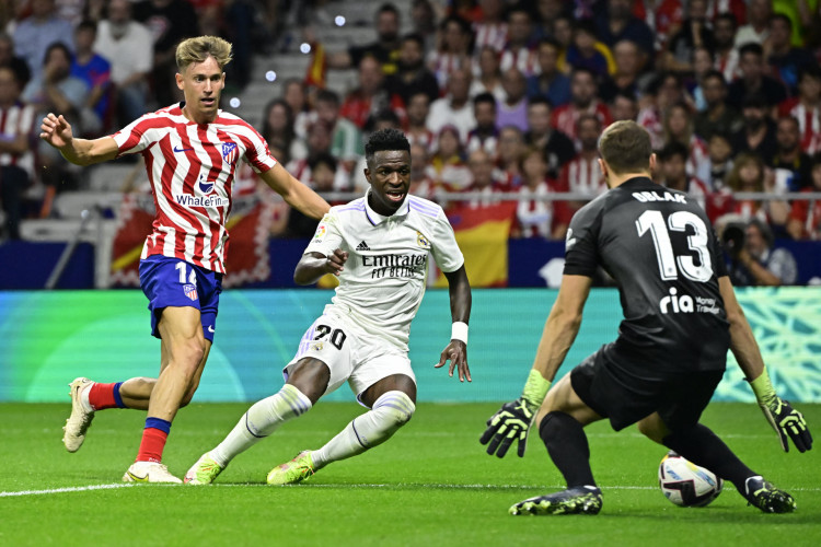 O atacante brasileiro Vinicius Junior, do Real Madrid, foi xingado com cantos racistas pela torcida do Atlético de Madrid. Na imagem, o brasileiro disputa com o meia Marcos Llorente (à esquerda), espanhol do Atlético de Madrid, durante a partida no estádio Wanda Metropolitano, neste domingo, 18 de setembro de 2022