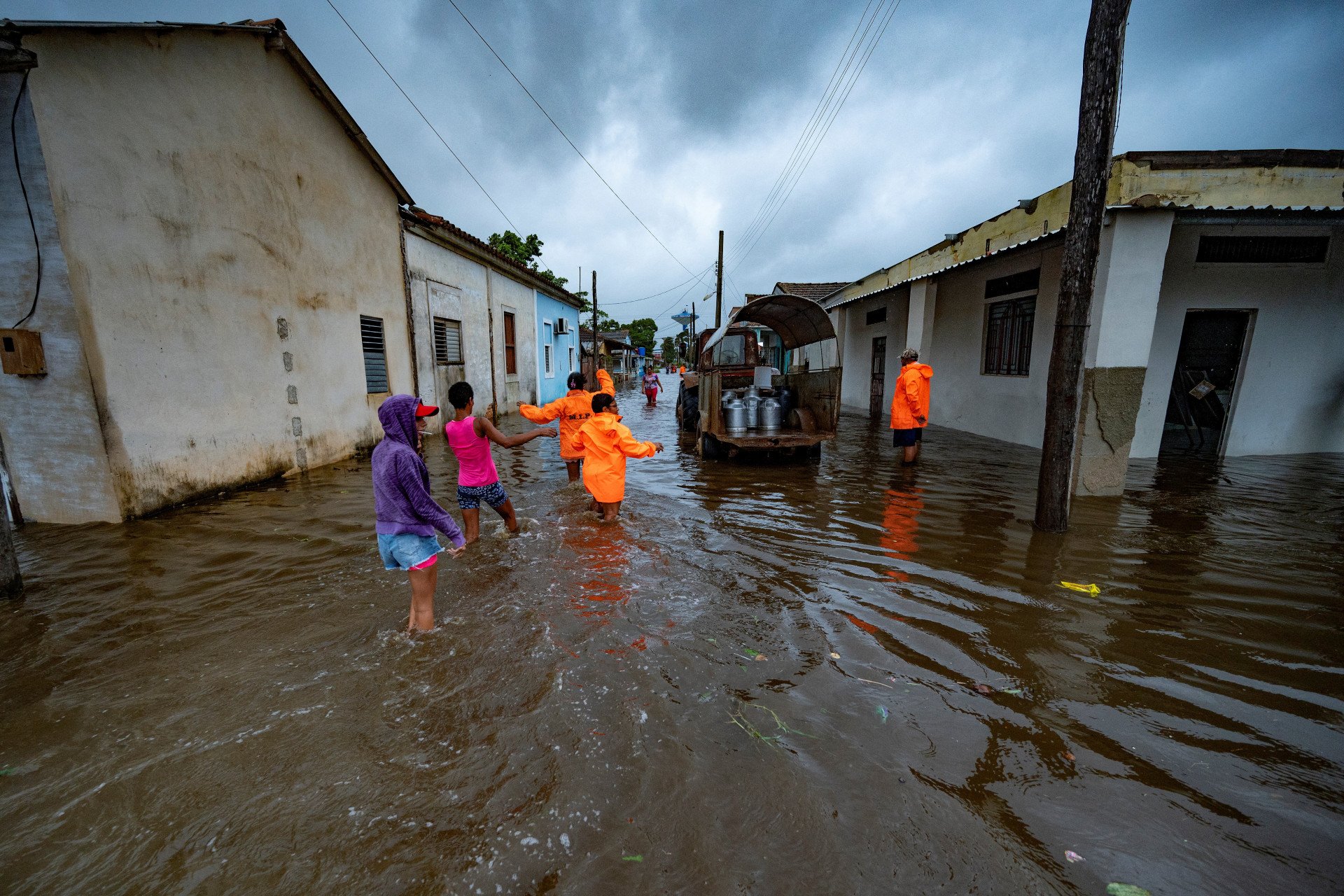 Pessoas caminham por uma rua inundada em Batabano, Cuba, em 27 de setembro de 2022, durante a passagem do furacão Ian. O furacão Ian atingiu o oeste de Cuba na terça-feira, com a tempestade provocando evacuações em massa e temores de que trará destruição generalizada à medida que se dirige para o estado norte-americano da Flórida.
 (Foto: YAMIL LAGE / AFP)