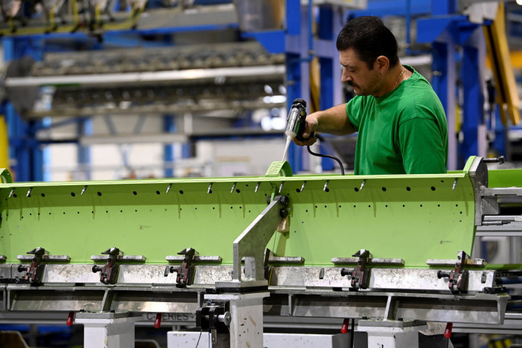 Um homem está trabalhando no salão de produção da empresa aeroespacial Sonaca 