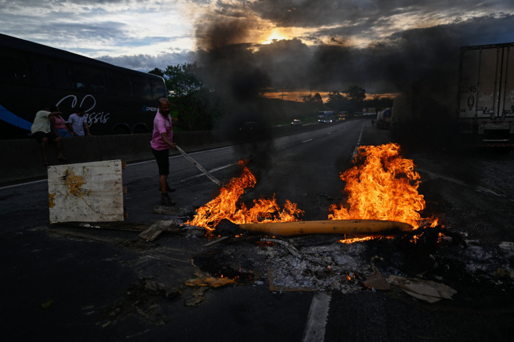 Apoiadores do presidente Jair Bolsonaro, principalmente caminhoneiros, incendiaram uma barreira durante um bloqueio na rodovia Via Dutra BR-116 entre Rio de Janeiro e São Paulo, em Volta Redonda, estado do Rio de Janeiro, Brasil, em 31 de outubro de 2022, como protesto pela derrota de Bolsonaro no segundo turno da eleição presidencial