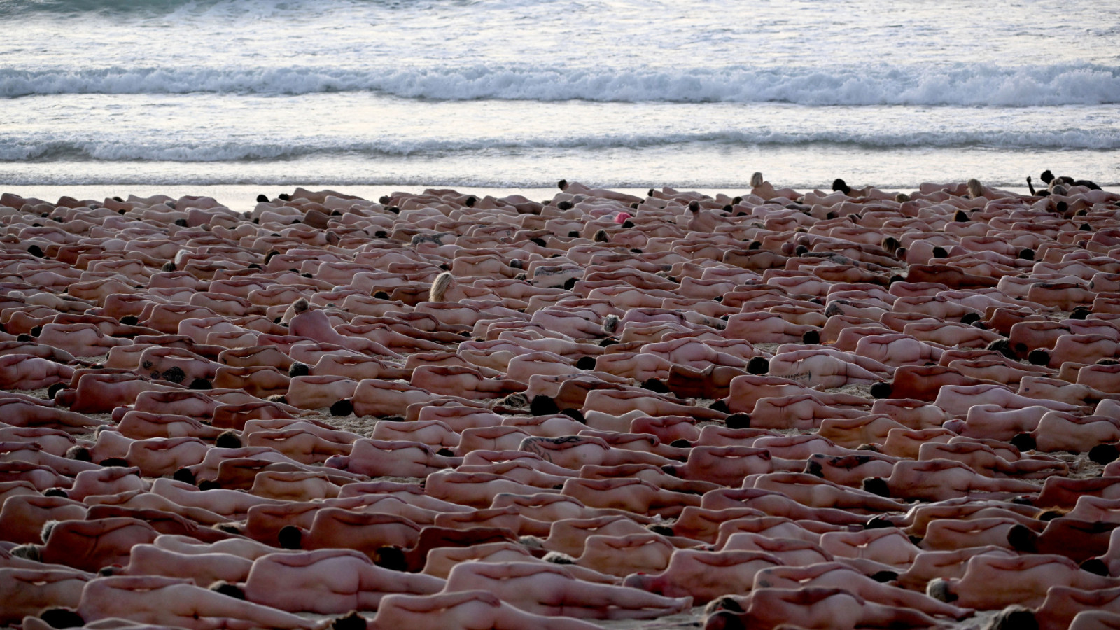 Participantes posam nus durante o nascer do sol em Bondi Beach, em Sydney, para o fotógrafo de arte norte-americano Spencer Tunick, para aumentar a conscientização sobre o câncer de pele, em 26 de novembro de 2022