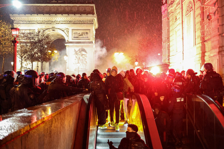 A polícia nacional francesa evacua os últimos torcedores de futebol restantes em direção à entrada do metrô de transporte público perto do Arco do Triunfo, após a derrota da França na última partida de futebol da Copa do Mundo do Catar 2022 entre Argentina e França no centro de Paris em 18 de dezembro de 2022