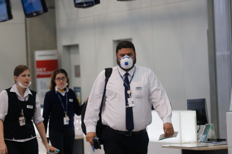 Passageiros e funcionários circulam vestindo máscaras contra o novo coronavírus (Covid-19) no Aeroporto Internacional Tom Jobim- Rio Galeão. (Fernando Frazão/Agência Brasil)