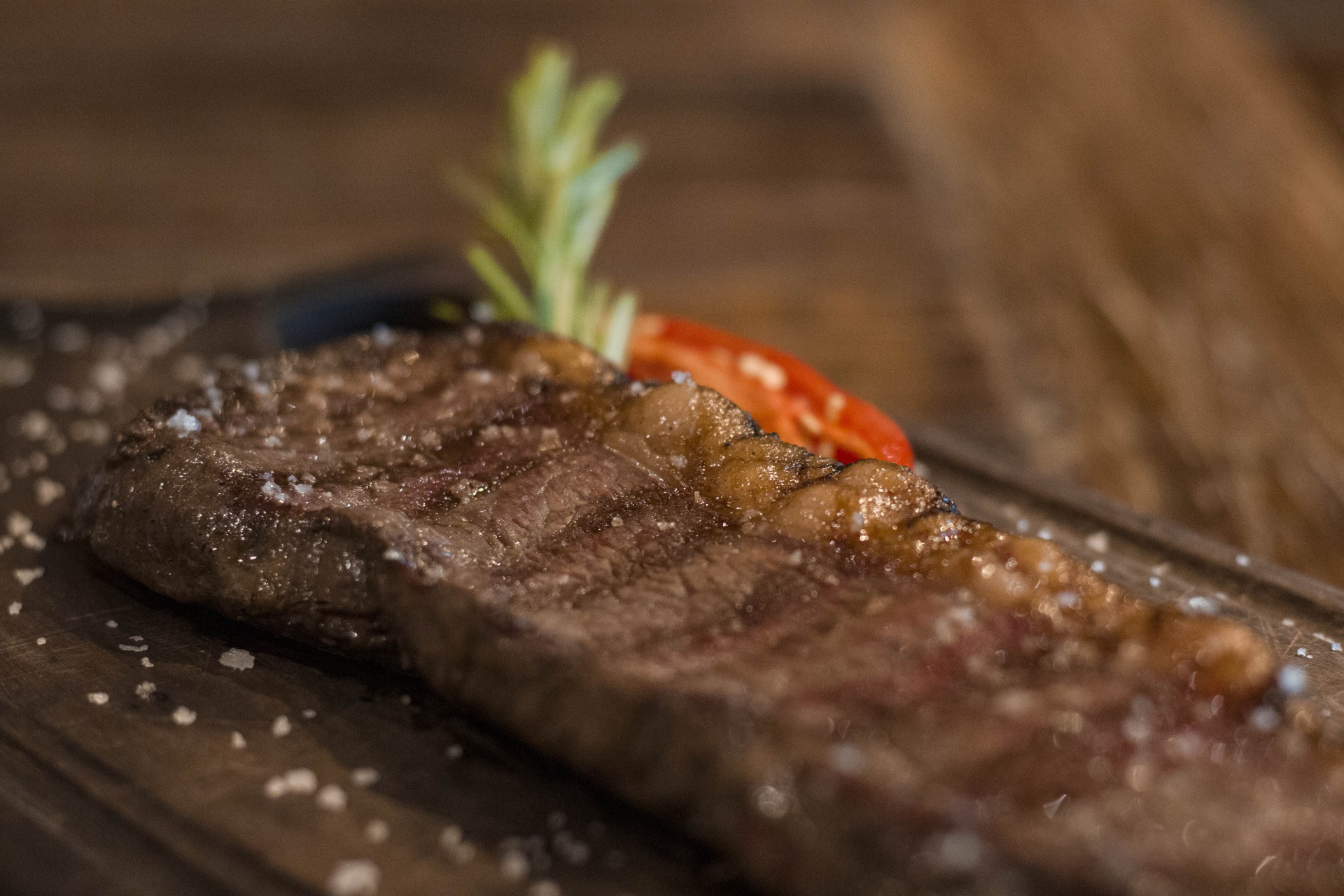 Espetinhos de carne sobre tábua de madeira com farofa de limão e pimenta