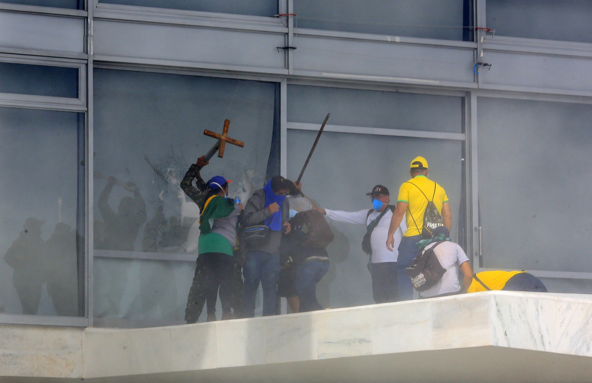 ￼APOIADORES de Bolsonaro quebram janelas e invadem o Palácio do Planalto nos ataques golpistas de 8 de janeiro de 2023 (Foto: SERGIO LIMA/AFP)