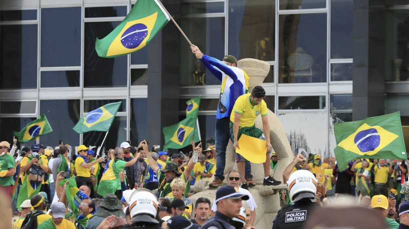 ￼Em frente ao STF, manifestantes em cima da estátua da Justiça