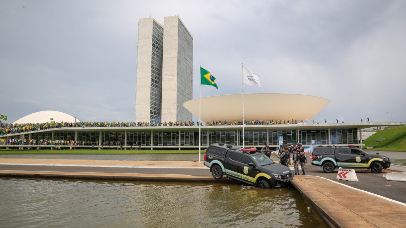 Congresso Nacional é invadido por apoiadores do ex-presidente Jair Bolsonaro, em 8 de janeiro de 2023. Veículo da Polícia Legislativa é jogado no espelho d'água