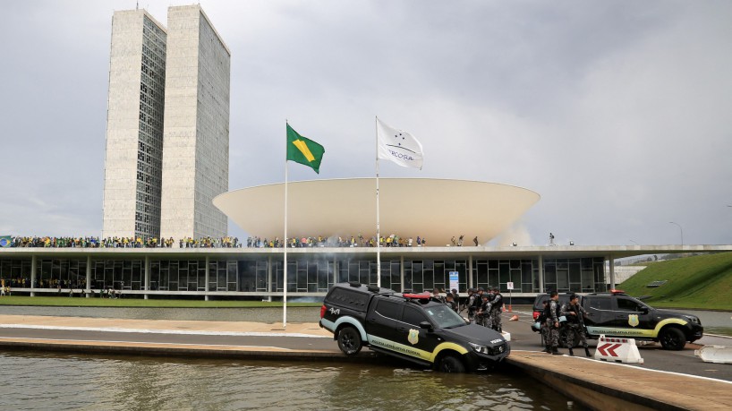 Apoiadores de Bolsonaro invadem o Congresso Nacional em 8 de janeiro de 2023. Veículo da Polícia é jogado no espelho d'água