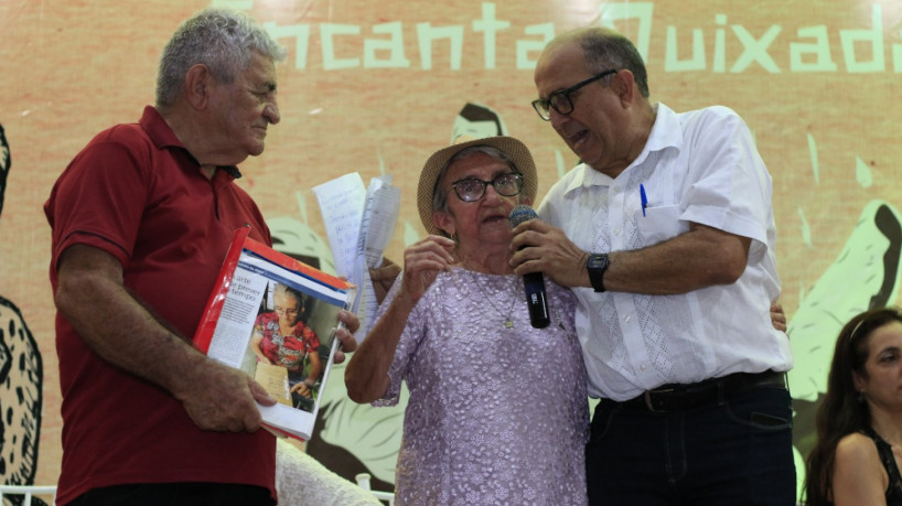 Dona Lurdinha, uma das profetisas participantes, ao lado do organizador do evento, Helder Cortez (de branco)