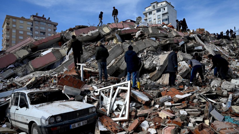 Moradores e equipes de resgate procuram vítimas e sobreviventes entre os escombros de edifícios em Kahramanmaras, na Turquia, após terremoto de magnitude 7,8 atingir o sudeste do país