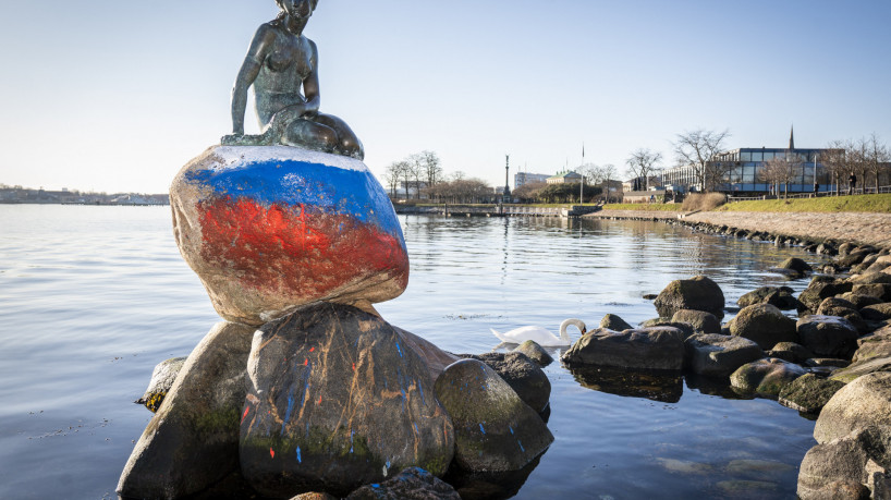 A escultura da Pequena Sereia, emblema de Copenhague e da Dinamarca, é retratada em 2 de março de 2023 em Copenhague, depois de ter sido vandalizada com a bandeira russa pintada na pedra em que ela está sentada