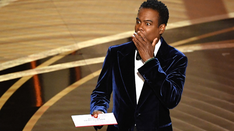 Nesta foto de arquivo tirada em 27 de março de 2022, o ator americano Chris Rock fala no palco durante o 94º Oscar no Dolby Theatre em Hollywood, Califórnia. Chris Rock finalmente revidou Will Smith em 4 de março de 2023 em uma brutal rotina de stand-up, um ano depois que o ator o esbofeteou na frente de uma audiência global de TV para o Oscar