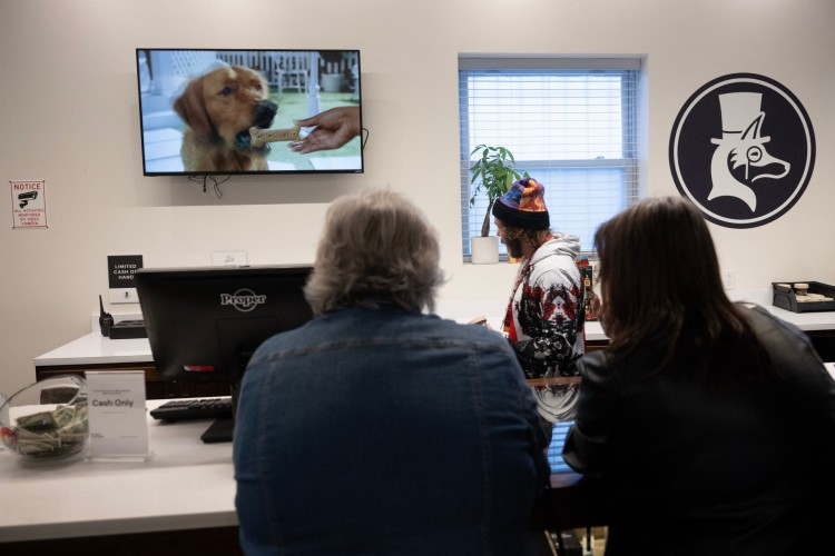 Chris Brown busca produtos de cannabis enquanto ajuda as usuárias recreativos Juree Burgett e Tanya Knight, no dispensário Proper Cannabis em Kansas City, Missouri, em 17 de março de 2023