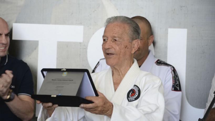 Rio de Janeiro - O ministro do Esporte, Leonardo Picciani, entrega homenagem ao professor Robson Gracie, um dos pioneiros e principais responsáveis pelo desenvolvimento do estilo de arte marcial Jiu Jitsu no Brasil durante evento na Casa Brasil, no Pier Mauá, zona portuária da capital. (Tomaz Silva/Agência Brasil)