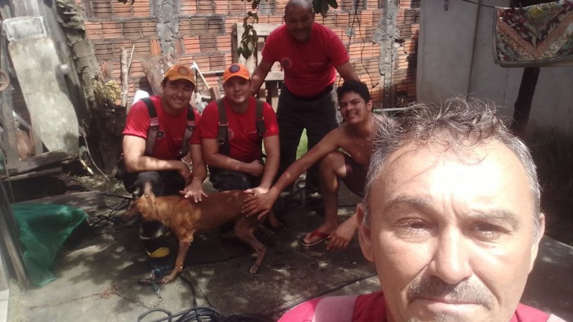 Zayon, junto com seu tutor, posa para foto ao lado da guarnição que realizou o salvamento 