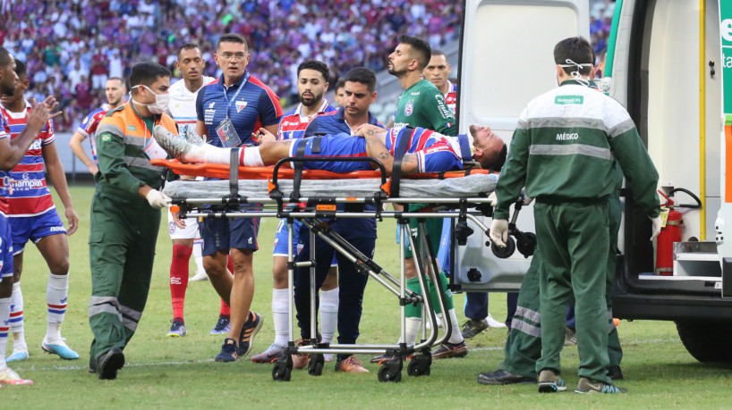 O jogador Guilherme, do Fortaleza, deixa o campo de ambulância após se chocar com o goleiro Marcos Felipe, do Bahia