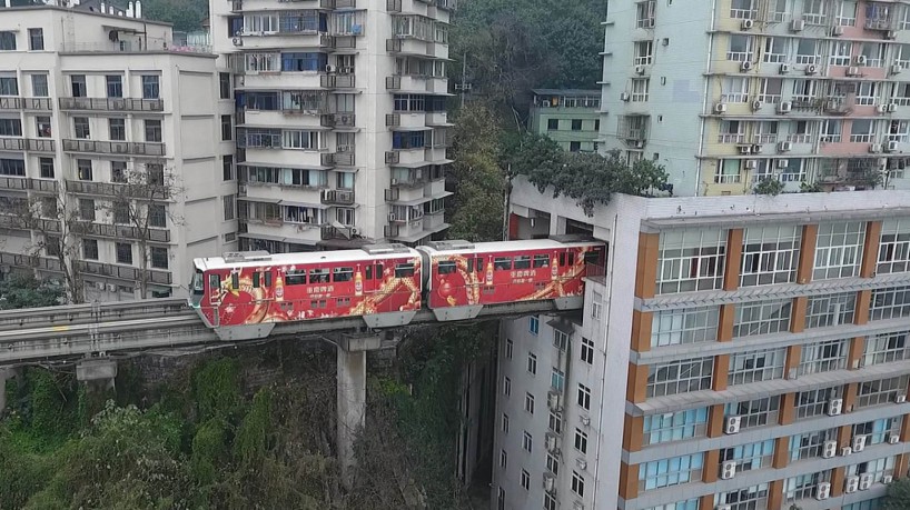 O trem passa dentro de prédio, em Chongqing, na China