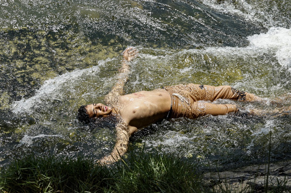 Jovem se refresca no rio Nilo, no Egito, durante onda de calor(Foto: Khaled DESOUKI / AFP)