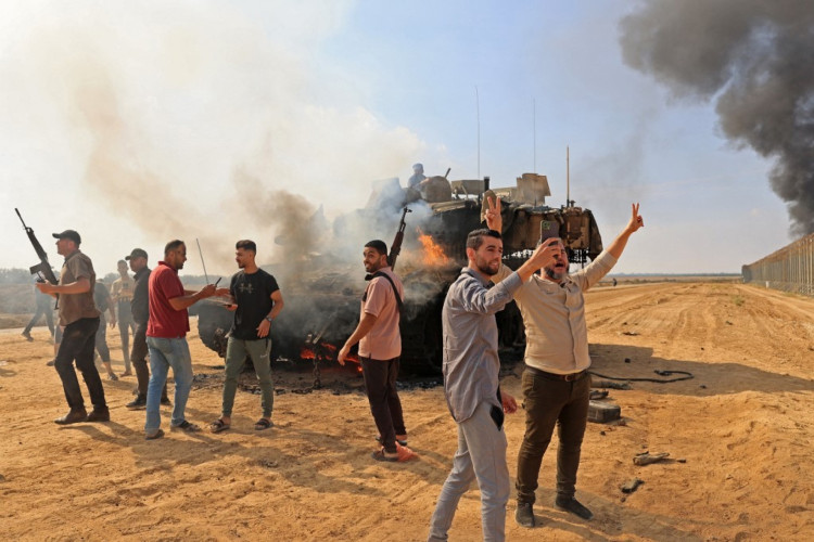 Palestinos assumem o controle de um tanque israelense após cruzarem a cerca da fronteira com Israel de Khan Yunis, no sul da Faixa de Gaza, em 7 de outubro de 2023. Barragens de foguetes foram disparadas contra Israel a partir da Faixa de Gaza ao amanhecer, enquanto militantes do enclave palestino bloqueado se infiltravam em Israel , com pelo menos uma pessoa morta, disseram o exército e os médicos