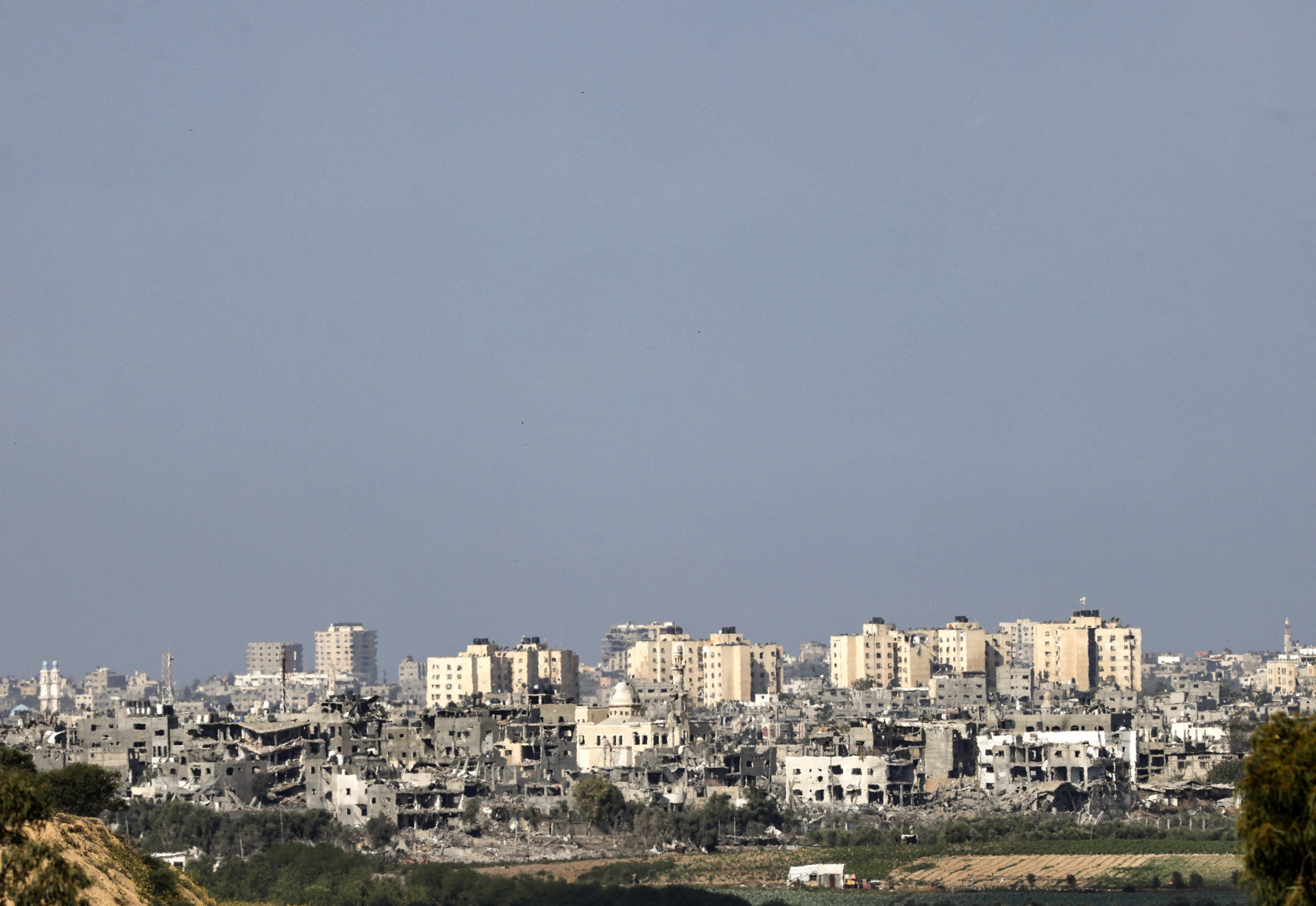 Uma foto tirada da cidade de Sderot, no sul de Israel, mostra edifícios danificados no norte da Faixa de Gaza (Foto: RONALDO SCHEMIDT / AFP)