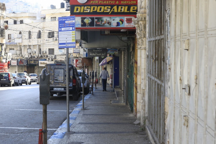 Palestino passa por lojas fechadas durante uma greve geral em Nablus, na Cisjordânia ocupada um dia depois de um foguete atingir um hospital em Gaza