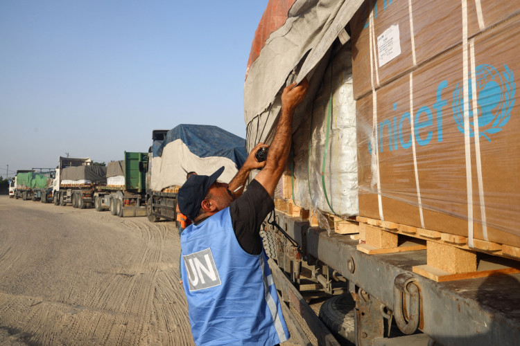 Um funcionário das Nações Unidas verifica a ajuda humanitária num comboio de caminhões que entra na Faixa de Gaza vindo do Egito através da passagem da fronteira de Rafah, em 21 de outubro de 2023 