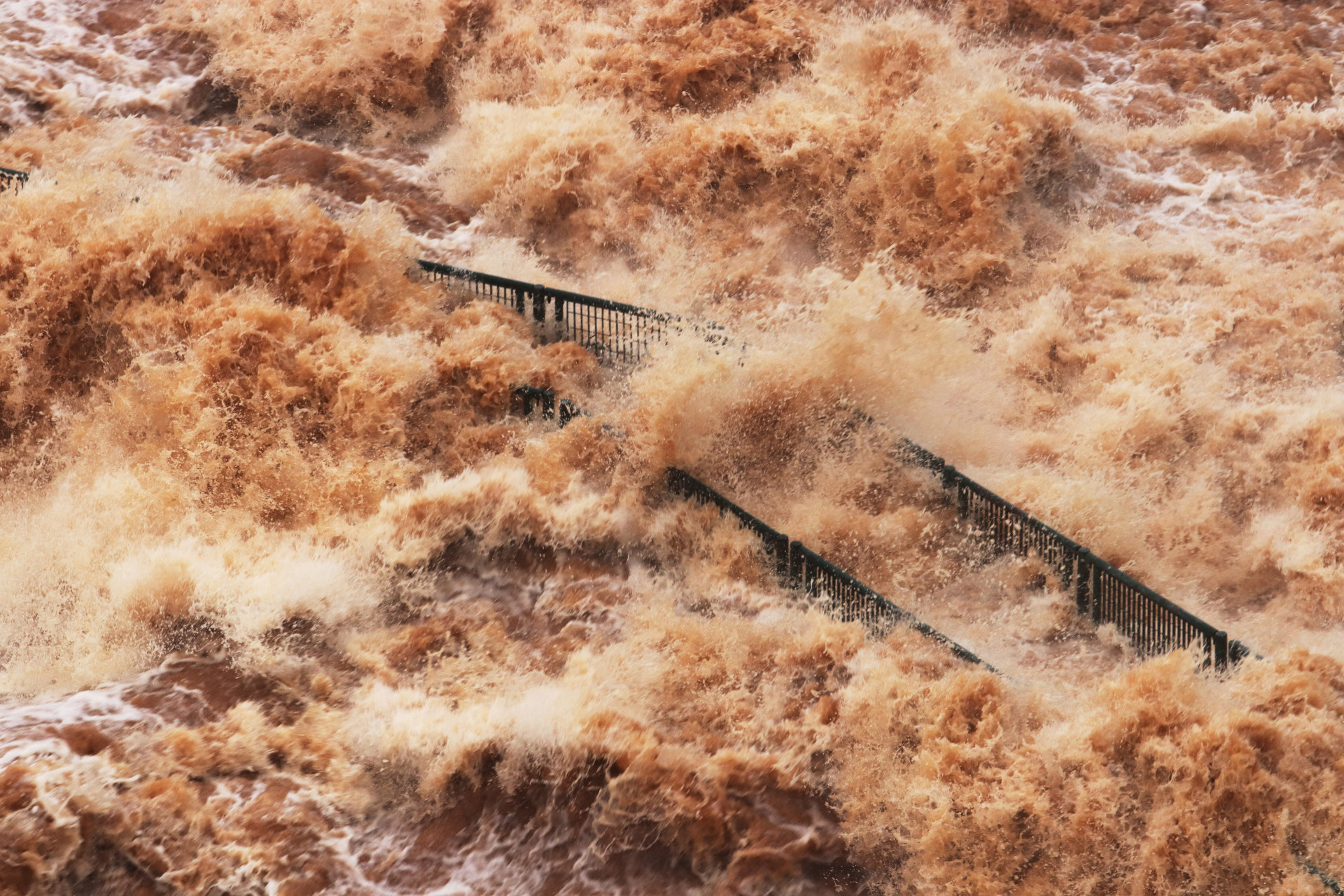 Vista da passarela de visitantes das Cataratas do Iguaçu, que foi destruída pela forte correnteza do rio na tríplice fronteira entre Brasil, Argentina e Paraguai, em 30 de outubro de 2023. As Cataratas estão fluindo a mais de 24 milhões de litros de água por segundo , conforme monitoramento hidrológico da Companhia Paranaense de Energia (Copel). Esta é a segunda maior vazão desde 1997, quando o monitoramento passou a ser automático e medido de hora em hora. (Foto: Christian Rizzi / AFP)